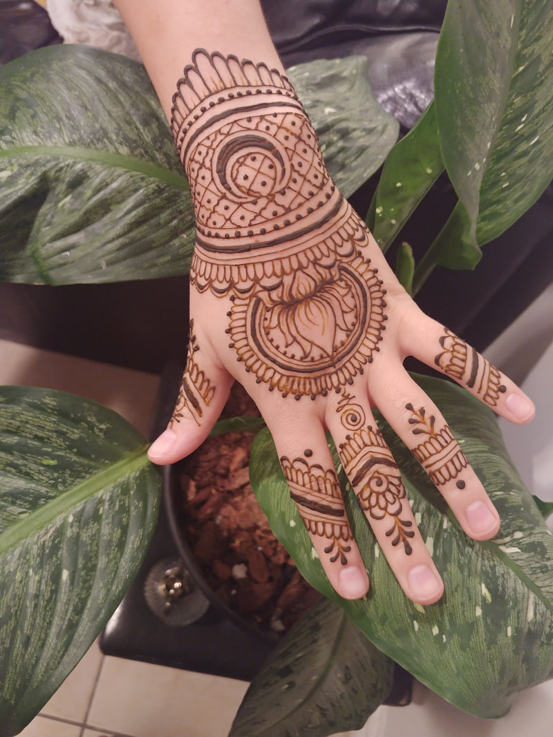 geometric lotus flower henna tattoo on womans hand