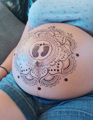 henna belly blessing with mandala and baby feet prints