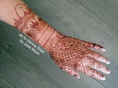 Dark henna hand design with organic henna paste