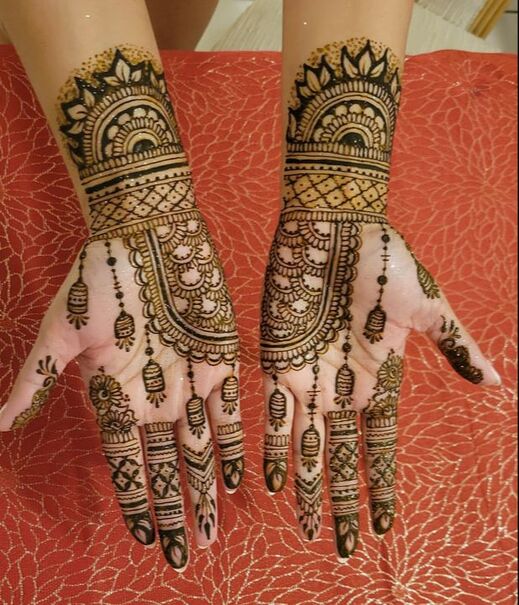 bridal henna hands over red draping 