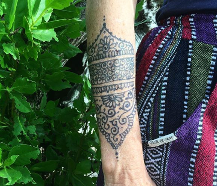 jagua gel tattoo on an arm in front of a green bush